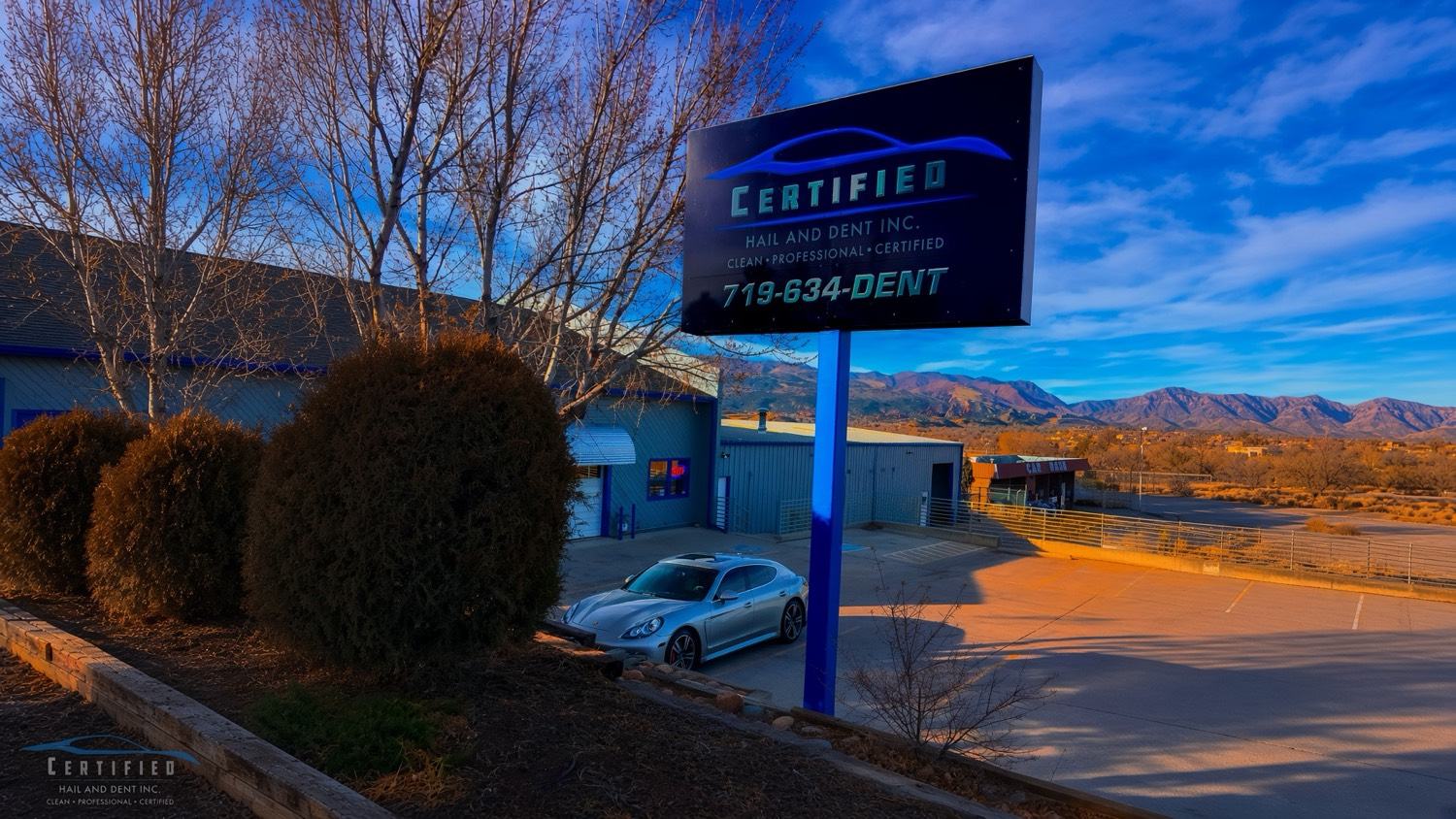 Certified Hail and Dent shop sign in Colorado Springs with Pikes Peak mountains