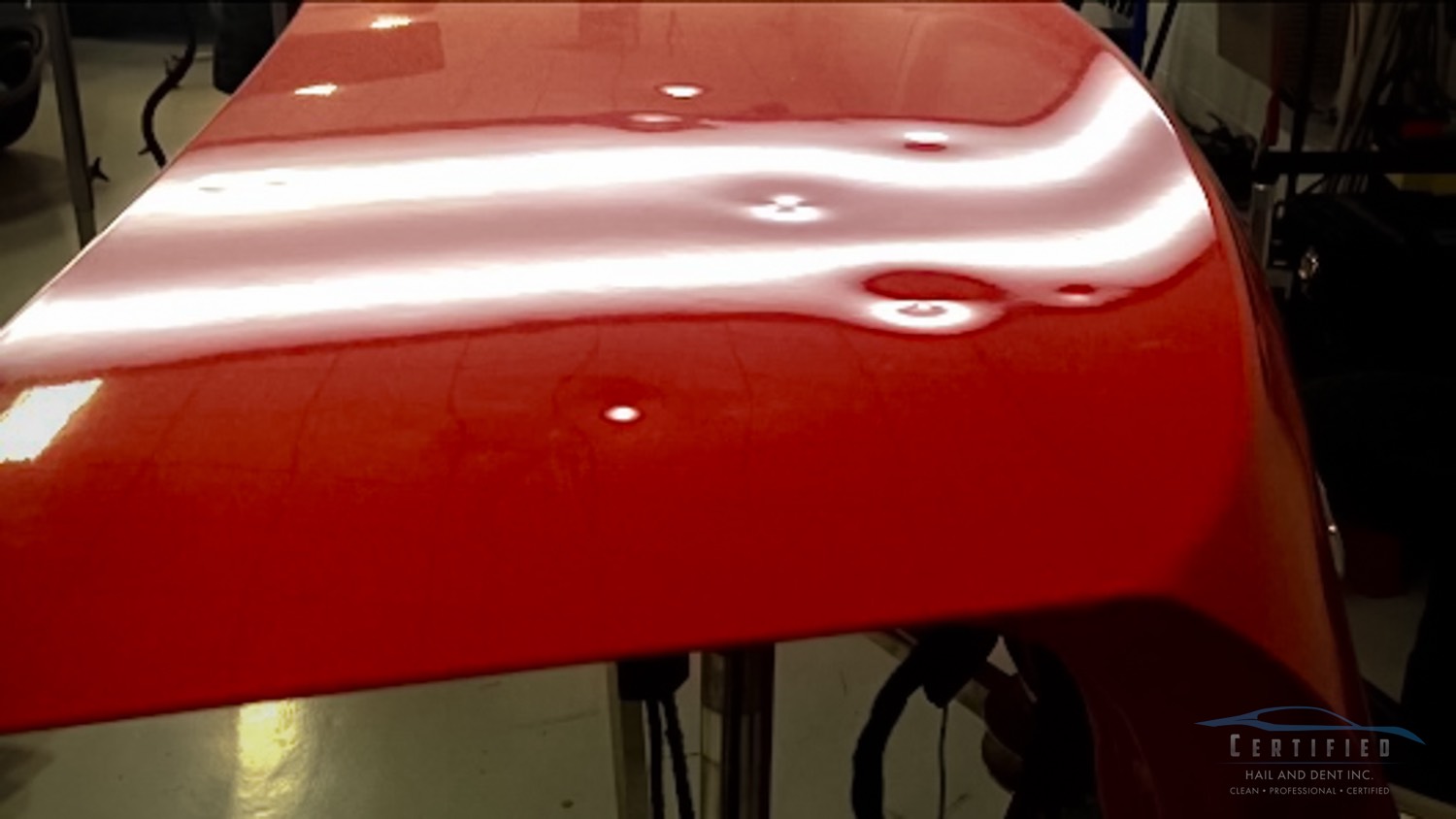 Before paintless dent repair showing hail damage on vehicle hood in Colorado Springs